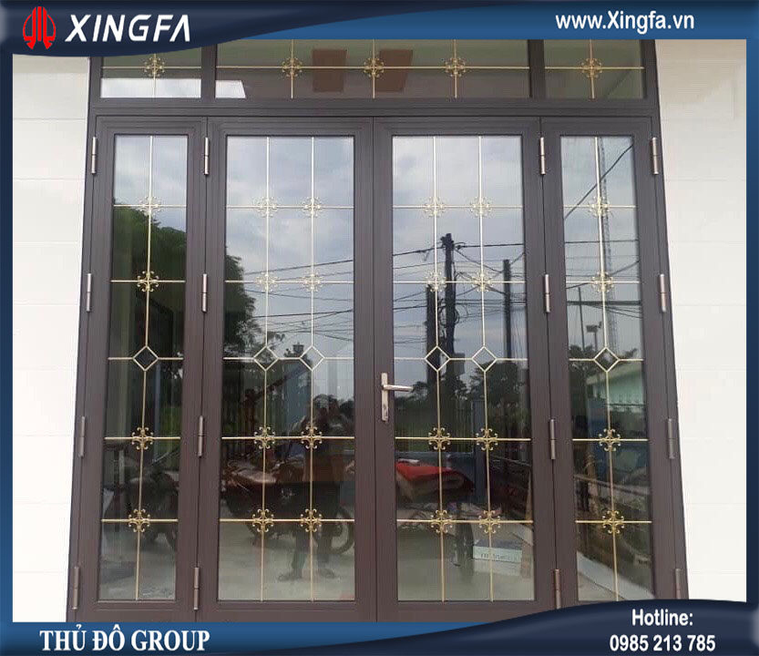 Mẫu cửa nhôm Xingfa dùng kính hộp 2 lớp hút chân không + ở giữa có nan trang trí mạ đồng